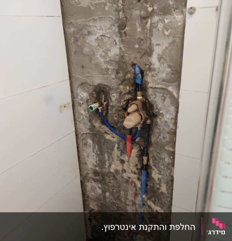 צנרת מים חשופה בקיר עם ברזים